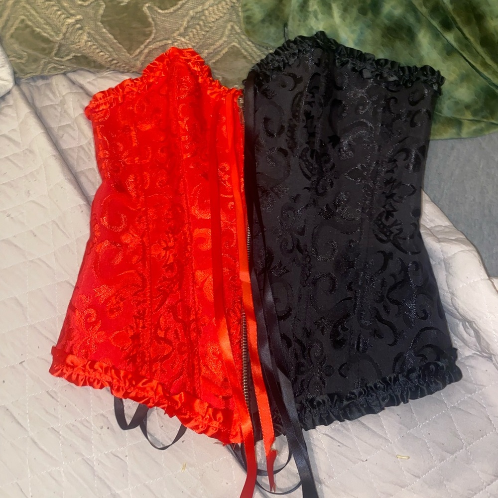 Red and black corset top. Zips up and ties to make tighter. Never worn.